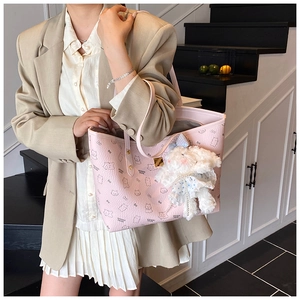 Pink lychee texture tote bag with cartoon bear patterns and a plush rabbit pendant detail