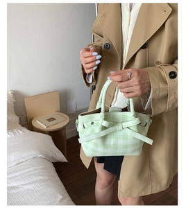 Détail du sac à main à carreaux vert menthe avec un nœud assorti et un crochet en D en métal