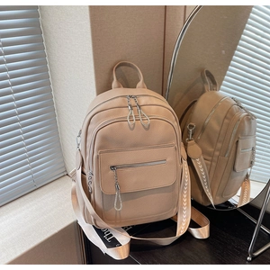 Detail of beige lychee grain leather backpack with diamond-encrusted ring zipper pull