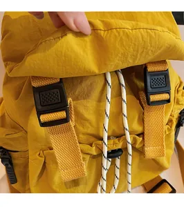 Détail du sac à dos en nylon jaune avec boucle en plastique noir et cordon de serrage
