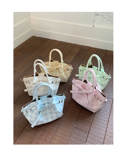 Détail de cinq mini sacs cabas à carreaux colorés avec décorations de nœuds