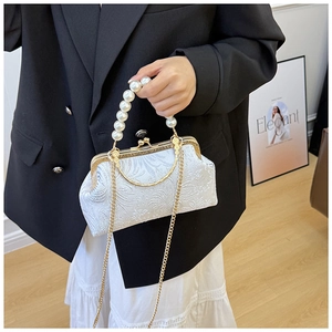 Detail of vintage floral jacquard shell bag with elegant pearl handle and metal clasp