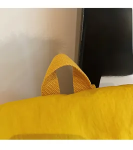 Détail de la poignée supérieure en nylon jaune avec sangle renforcée pour sac à dos