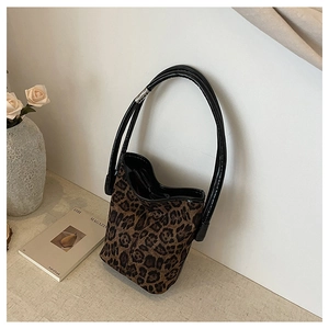Detail of leopard print bucket bag with suede texture and black tubular handles