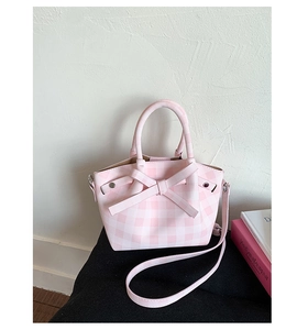 Vue détaillée du sac à main à carreaux rose et blanc avec nœud et bandoulière amovible