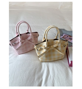 Détail de sacs cabas à carreaux roses et jaunes avec nœuds et rivets métalliques