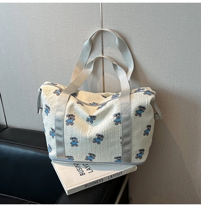 Close-up of white bubble texture fabric and blue bear pattern on travel tote bag