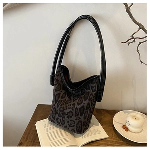 Macro detail of the leopard print pattern and wavy edge on a textured bucket shoulder bag