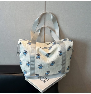 Close-up of foldable travel bag featuring embossed bubble fabric and cute cartoon bear patterns