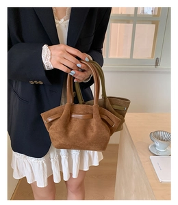 Detail of vintage matte suede bucket bags in caramel brown and olive green colors