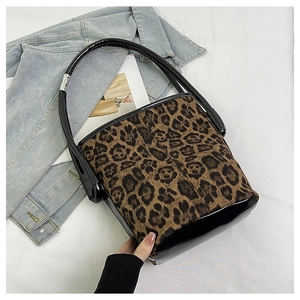 Close-up of leopard print bucket bag with patent leather base and casual denim styling