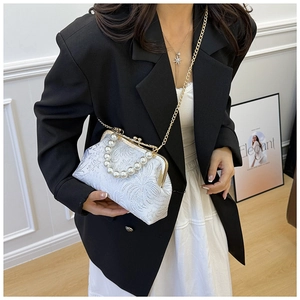 Detail of floral brocade shell bag with elegant pearl handle and gold chain strap