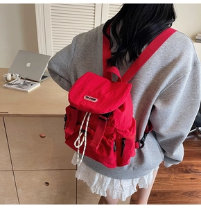 Détail d'un sac à dos en nylon rouge résistant à l'eau avec rabat et cordon de serrage