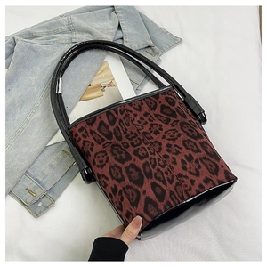 Top view of a leopard print bucket bag with black patent leather base and handle strap