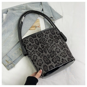 Detail of leopard print bucket bag with smooth black PU leather handle and base texture