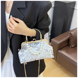 Detail of vintage floral brocade shell bag with pearl handle and gold chain strap
