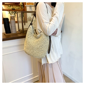 Detail of handwoven straw tote with premium brown leather strap and texture