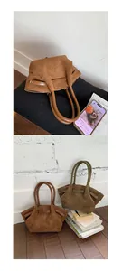 Close-up of caramel brown and olive green suede tote bags with leather handles