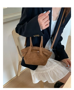 Brown suede tote bag shown on a model, featuring retro pleats and round top handles
