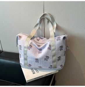 Macro detail of lavender quilted travel bag with bear print and sturdy woven handles