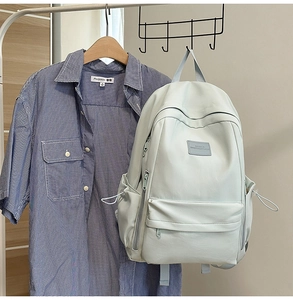 Detail of light mint green leather backpack with drawstring side pockets and top handle