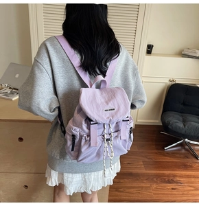 Vue détaillée du sac à dos en nylon violet avec fermeture à cordon et rabat stylé