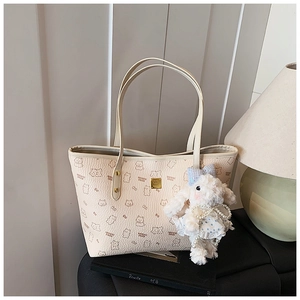 Detail of off-white tote bag with bear print and cute plush rabbit accessory