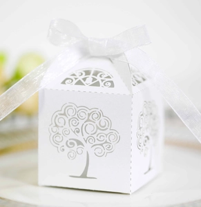 Close-up of white laser-cut hollow tree gift box with elegant white satin ribbon