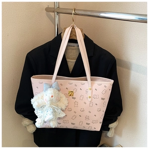 Detailed view of pink lychee textured tote bag with bear print and plush charm