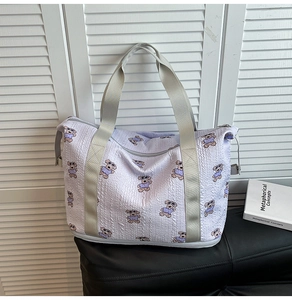 Detail of lavender travel bag showing cute bear prints and durable woven handles