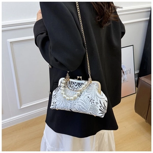 Detail of the vintage floral shell bag featuring elegant pearl handle and gold chain strap