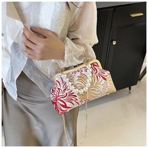 Detail of floral embroidery and pearl handle on a vintage-style brocade shell bag