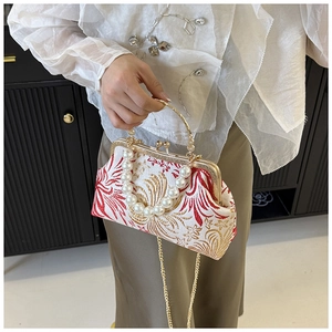 Detail of vintage embroidery pattern on handbag with pearl handle and metal clasp