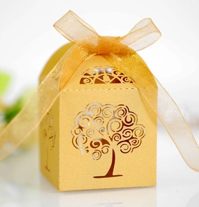 Close-up of golden hollow tree gift box with laser-cut details and organza ribbon