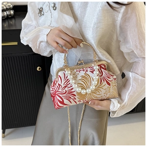 Detail of vintage embroidery pattern on handbag with pearl handle and metal chain