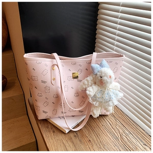 Close-up of light pink tote bag with cartoon print and plush rabbit charm detail