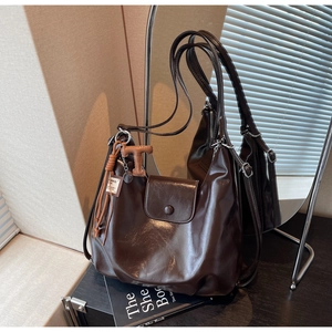 Detail of dark brown wax leather tote bag with flap closure and retro finish