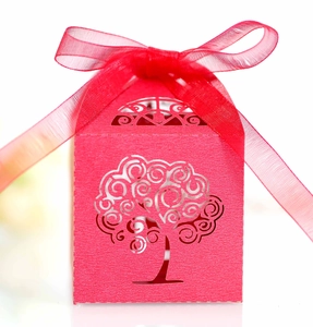 Detail of red laser-cut candy box with hollow tree design and organza ribbon