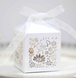 Detailed laser-cut white favor box with bear pattern and elegant white organza ribbon