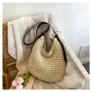 Detail of handwoven straw tote bag with brown straps and white braided texture for summer