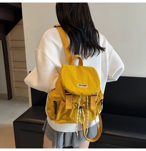 Detailed back view of lightweight yellow nylon backpack with flap and drawstring closure