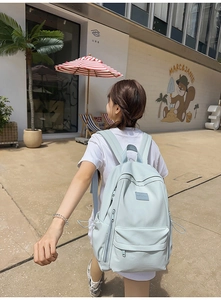 Close-up of a light blue waterproof nylon backpack with functional side zipper pockets