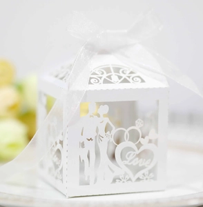 Détail de la boîte à dragées blanche ajourée avec texte Love et silhouette de mariés