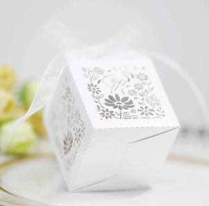 Close-up of white laser-cut floral candy box with an elegant organza ribbon detail