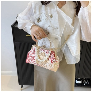 Detail of vintage Chinese embroidery bag featuring elegant pearl handle and gold chain
