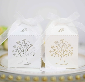 Detailed laser-cut tree design on elegant white party favor boxes with ribbon bow