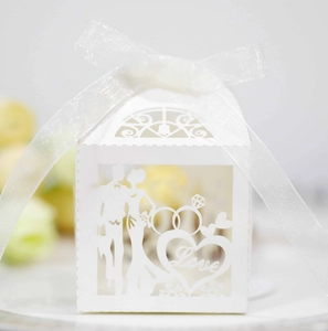 Détail macro de la découpe laser en cœur sur boîte à dragées de mariage blanche chic