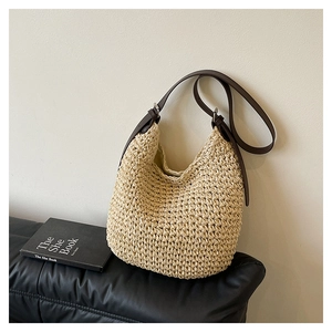 Close-up of woven straw bag texture with brown leather strap and fine metal hardware