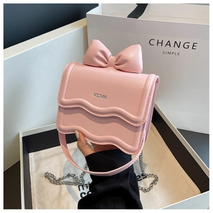 Detail of pink leather mini bag with wave flap, bow ornament and silver KCMK logo