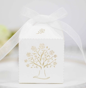 Detail of white square gift box featuring a gold floral tree design and white silk ribbon